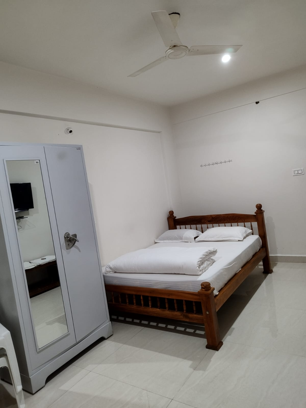 Bright guest room with wooden double bed and wardrobe